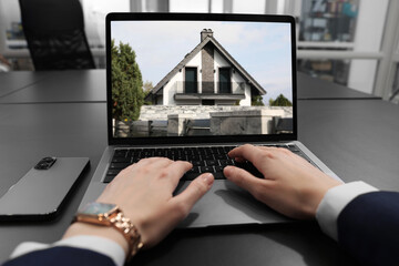 Wall Mural - Woman looking for house on real estate market website at table, closeup