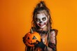 © Zanni - happy girl with face painting dressed up for halloween on orange background