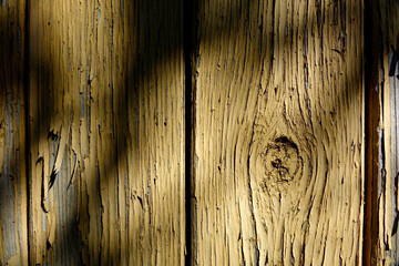 Poster - Old Wooden Wall With Cracked Paint Showcasing Rich Texture and Shadows in Natural Light