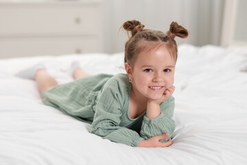 Wall Mural - Portrait of happy little girl on bed at home