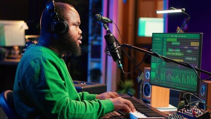 Leinwandbilder - Artist recording new tracks by playing piano notes on electronic keyboard in his home studio, working with audio stereo gear to mix and master tunes. African american musician. Camera A.