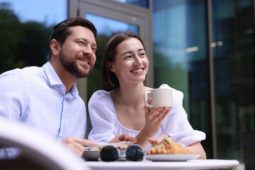 Canvas Print - Happy couple having breakfast in outdoor cafe