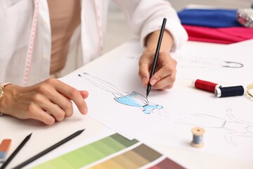 Wall Mural - Fashion designer drawing sketch of dress at table in workshop, closeup