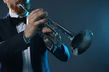 Wall Mural - Professional musician playing trumpet on dark background, closeup