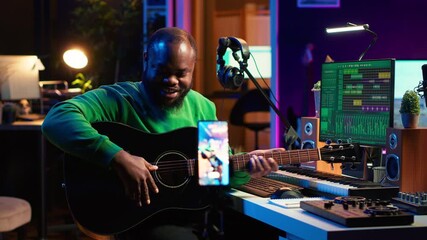 Poster - Professional composer teaching guitar lessons online on master class, recording himself playing acoustic instrument accords and explaining notes for tutorial. Young musician making vlogs. Camera A.