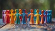 © Manon - Multicolored paper cutout figures holding hands in a circle, symbolizing unity, diversity, and teamwork