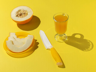 Wall Mural - Fresh Yellow Melon with Juice and Knife on Bright Yellow Background