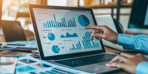 Leinwandbilder - A business professional pointing at an appraisal report on a laptop screen, surrounded by financial documents and charts, showcasing in-depth analysis and evaluation