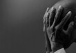 © herlanzer - man praying to god with hands together Caribbean man praying with black grey background with people stock image stock photo