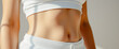 © Rysak - Close-up of a woman's toned stomach in white sportswear