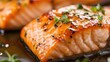 © arthit - Close-up of a perfectly cooked piece of salmon with a honey glaze and fresh herbs.