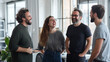 © forenna - Portraits of a group of businesspeople standing together in an office, laughing and engaging in lively conversation. The image captures the camaraderie and positive communication a