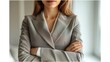 © Рудой Максим - Professional woman in a blazer stands confidently with arms crossed in a well-lit office setting