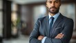 © Рудой Максим - Confident businessman in a suit stands with arms crossed in a modern office interior during the day