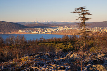 Wall Mural - Autumn landscape. View from the hill to the sea bay and the port city. Beautiful nature of Siberia and the Russian Far East. Travel in the Magadan region. Surroundings of the city of Magadan, Russia.