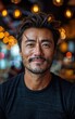© imagineRbc - A man with a mustache and a black shirt is smiling. He is looking at the camera. The image has a warm and friendly mood