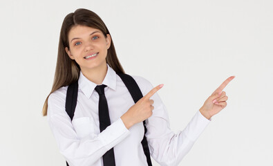 Wall Mural - Hey look. Smiling pretty female model pointing fingers right at empty space and inviting to check it out, showing advertisement on white background.