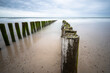 © natros - Linie von Holzpfählen im Meer bis zum Horizont