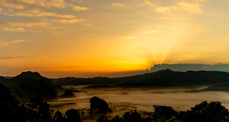 Wall Mural - Sunset mountain range beautiful landscape mist foggy sunrise beam. Golden sky Mountain landscape foggy windy mountain. Amazing Landscape cloud sky on sunrise. Countryside gold sunlight heaven scene