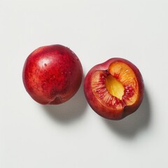 A close-up image of two small, ripe peach halves with the pits still attached.