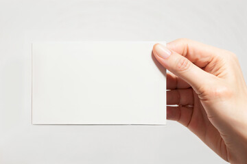 A hand holding a white card with no writing on it