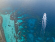 © Mat Hayward - A smal boat leaves a wake in the vibrant blue ocean water. Clear sea reveals coral reef off the shore of Bora Bora.