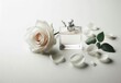 © Nattakarn - A stylish perfume bottle displayed with a delicate white rose and scattered petals on a minimalist white background..Concept: Purity, elegance, floral fragrance, romantic scent, simplicity