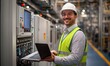 © Onchira - engineer in a factory, Caucasian smiling worker wearing white hat with green safety vest in industrial holding laptop to check and control electronic machine industry