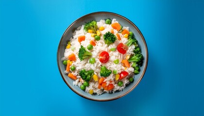 Wall Mural - Vegan rice with vegetables panorama, shot from the top on a blue background