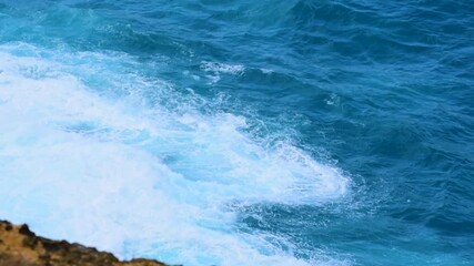 Wall Mural - Turquoise ocean sea water white wave pattern splashing deep blue sea. Seascape dark ocean background wave splash on rock. Tropical sea beach in summer seaside outdoor. Water Surface blue wave pattern