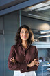 © Stock 4 You - Vertical portrait of beautiful hispanic business woman with crossed arms smiling at camera. European or latin confident young good looking middle age leader female businesswoman on office background