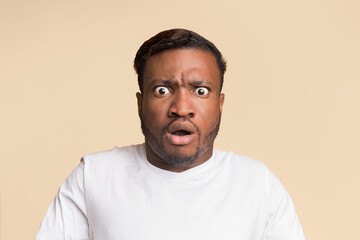 Wall Mural - Shocked Afro Man With Opened Mouth Looking At Camera Standing On Yellow Background. Studio Shot