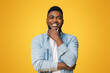 © Prostock-studio - Portraif of handsome bearded african american man touching his chin and smiling over yellow studio background, copy space