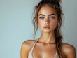 © Prime Stox - A young fitness woman in a dynamic sports bra, with her hair in a ponytail, on a white background
