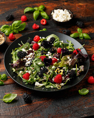 Wall Mural - Summer berries salad with edible flowers, feta cheese and seeds