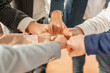 © Prostock-studio - A group of business professionals in formal attire stand in a circle and bump fists as a symbol of unity and agreement, closeup, cropped