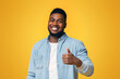 © Prostock-studio - Right choice. Portrait of smiling blach guy showing thumb up at camera over yellow background with free space