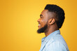© Prostock-studio - Cheerful african american man profile portrait. Black bearded guy looking aside at copy space on yellow studio background, panorama