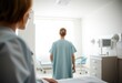 © Wanderson-oliveira - A young woman with long brown hair in a bun, wearing a light blue hospital gown, standing in a hospital room