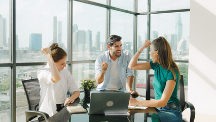 Professional business team receive a good news by using laptop while celebrate their success. Project manager high five and clap hands in front of laptop with colleague at modern office. Tracery