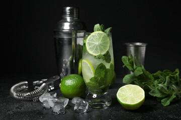 Wall Mural - Glass of cold mojito and ingredients on dark background