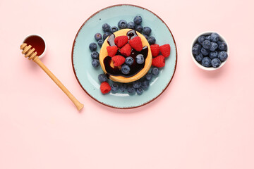 Wall Mural - Plate with sweet pancakes and berries on pink background