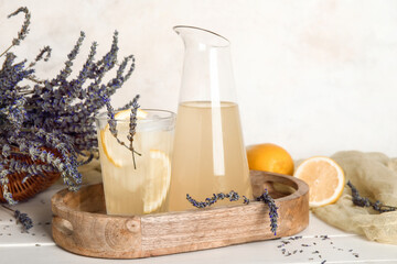 Wall Mural - Wooden board with glass and pitcher of cold lavender lemonade on light wooden table