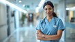 © Рудой Максим - Smiling healthcare professional in scrubs stands confidently in a hospital corridor during daylight hours