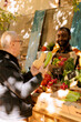 © DC Studio - Black male farmer displays organic vegetables from bio garden for elderly customer. Senior client selecting seasonal colorful locally grown fresh produce from greenmarket stand.