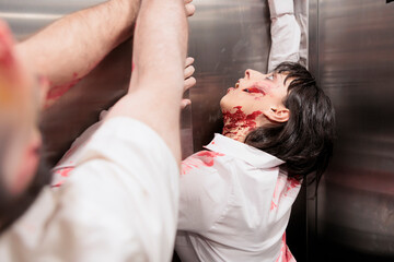 Actors playing zombies in horror movie scene, pretending to be stuck in elevator trying to evade to infect people. Man and woman with reanimated corpses role in thriller film trapped in escalator