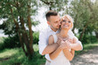 © anatoliycherkas - Happy Embrace of Newlywed Couple in Sunlit Outdoor Setting