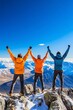 © atdigit - Excited Three Friends Celebrate Reaching Snowy Mountain Summit Under Clear Blue Sky