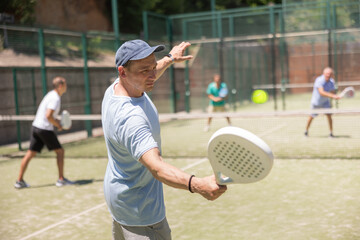 Wall Mural - Padel game - man with partners plays on tennis court