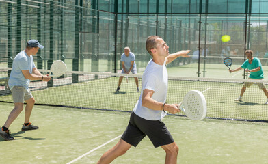 Wall Mural - Padel game - man with partners plays on tennis court